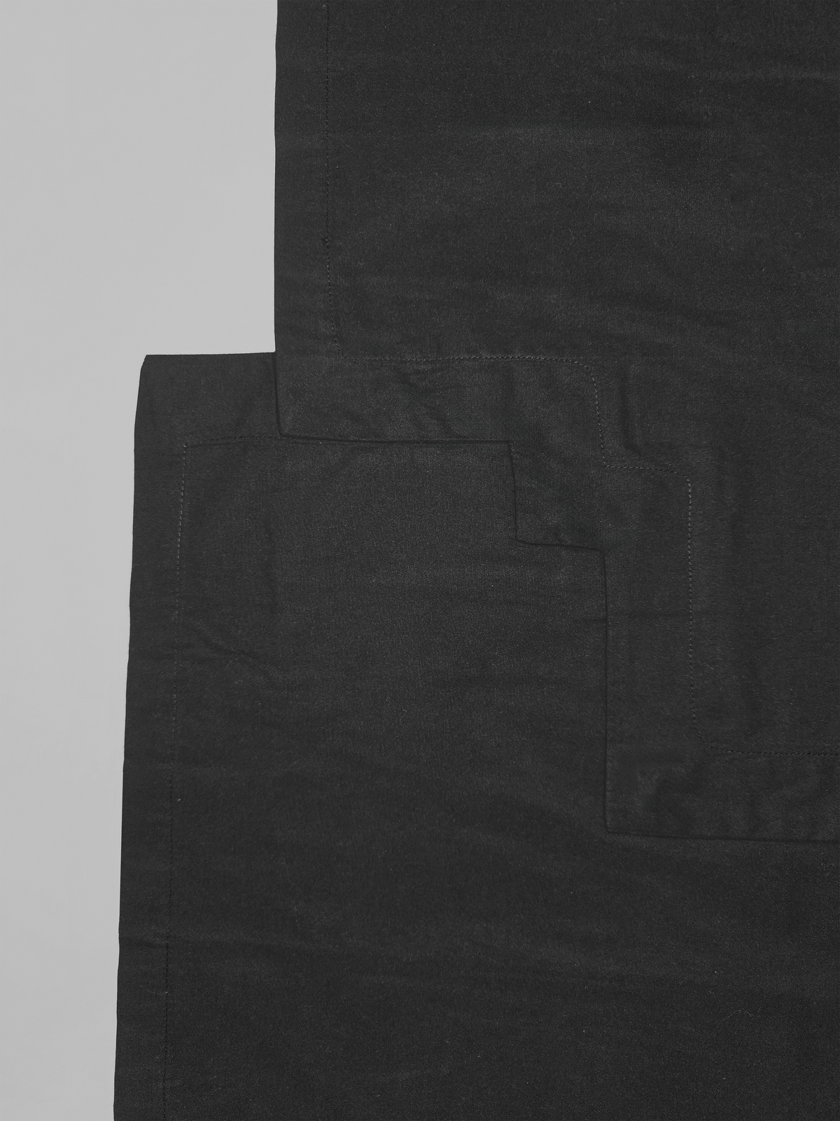 Détail du devant en bas de la chemise en coton Stephen, noire et asymétrique.