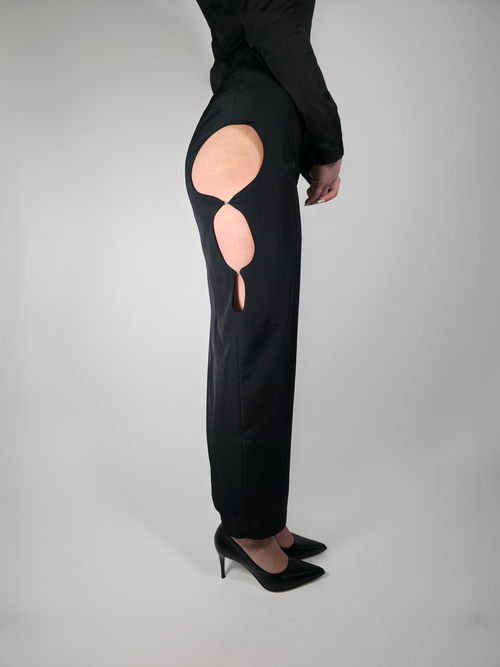 Détail des ouvertures latérales de la jupe longue crayon noire Théphaline, portée par une femme.