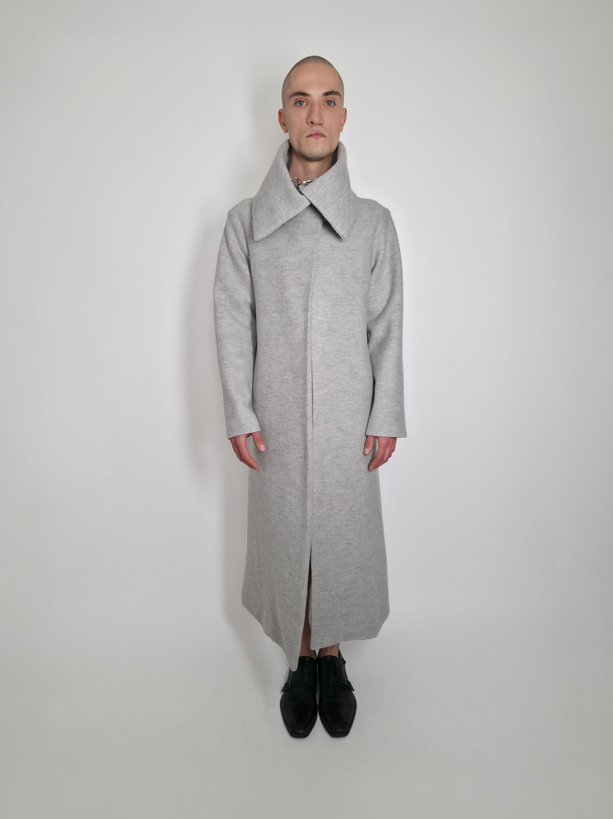 Homme portant le long manteau Michelle fermé gris en laine avec un grand col.