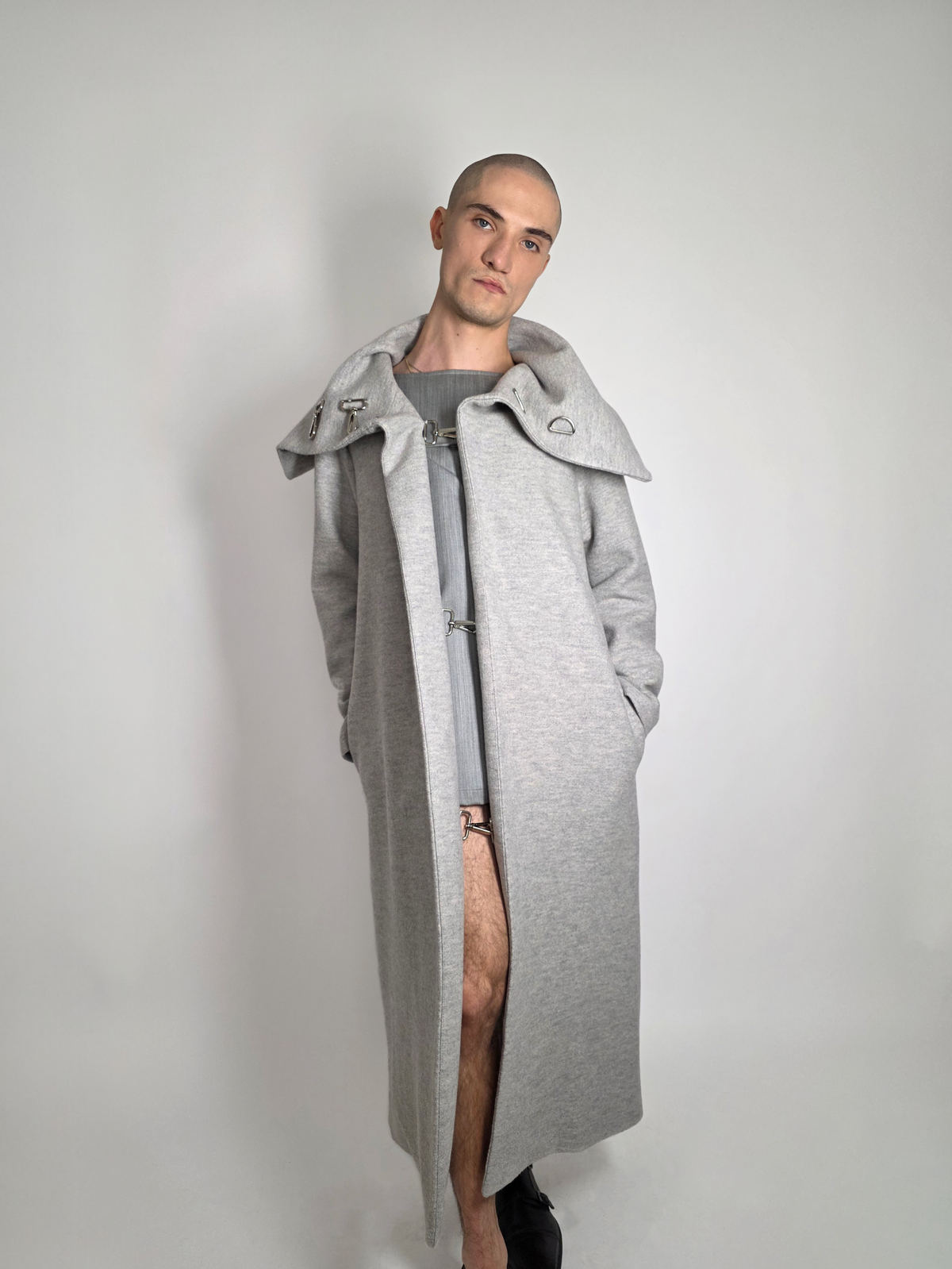 Homme portant le long manteau Michelle gris en laine avec la robe grise et courte Myshellie.