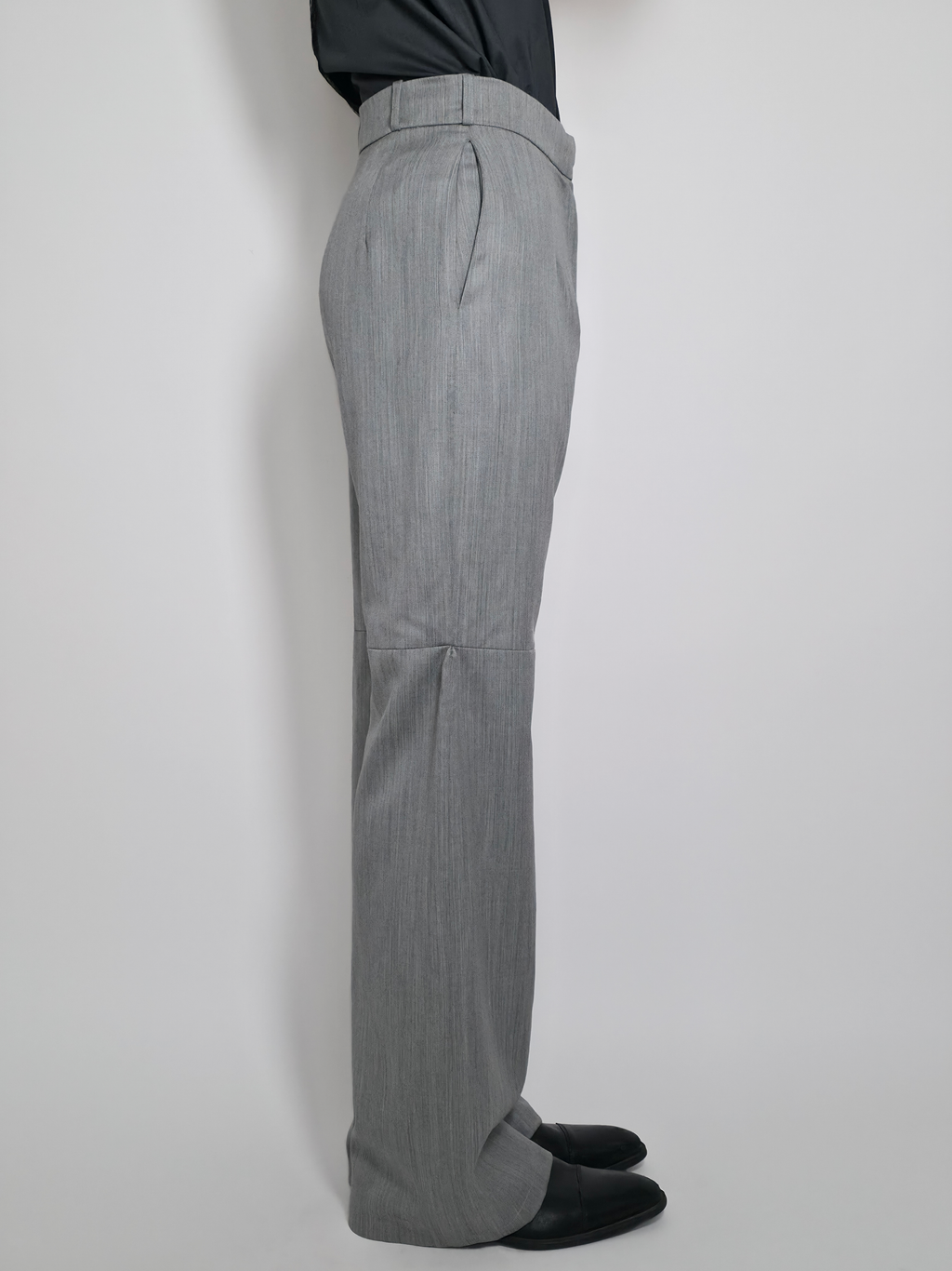 Vue de côté d’un homme portant le pantalon en laine Michael, gris taille haute et large.