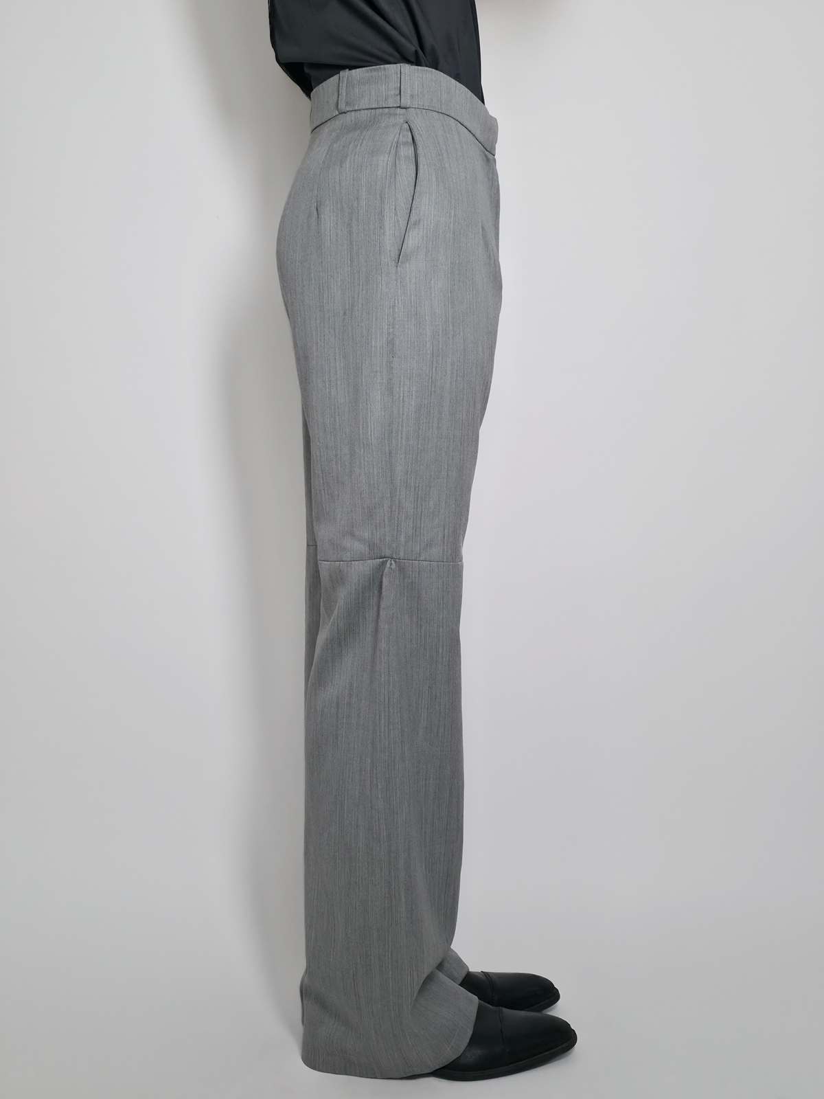 Vue de côté d’un homme portant le pantalon en laine Michael, gris taille haute et large.