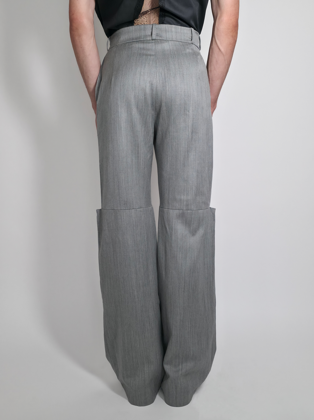 Vue de dos d’un homme portant le pantalon en laine Michael, gris taille haute et large.