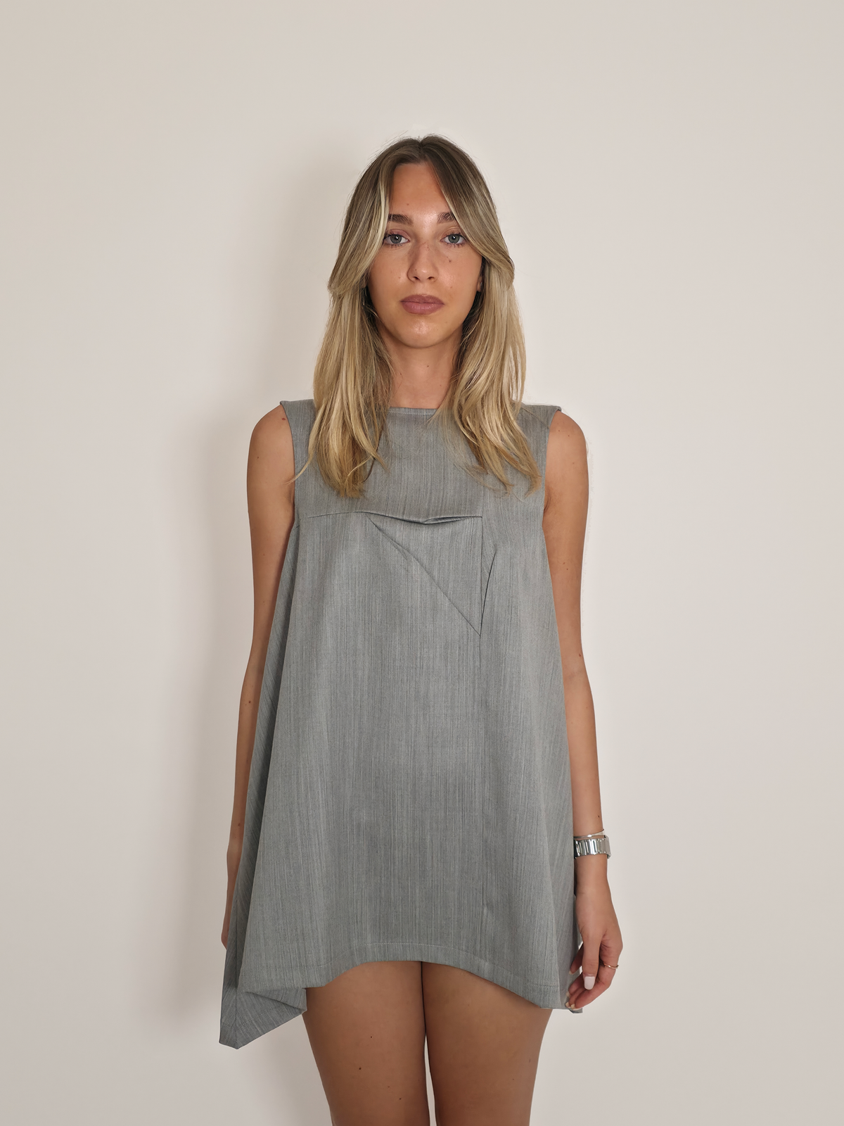 Femme portant la robe Myshellie courte grise en laine sans manches avec col bateau.