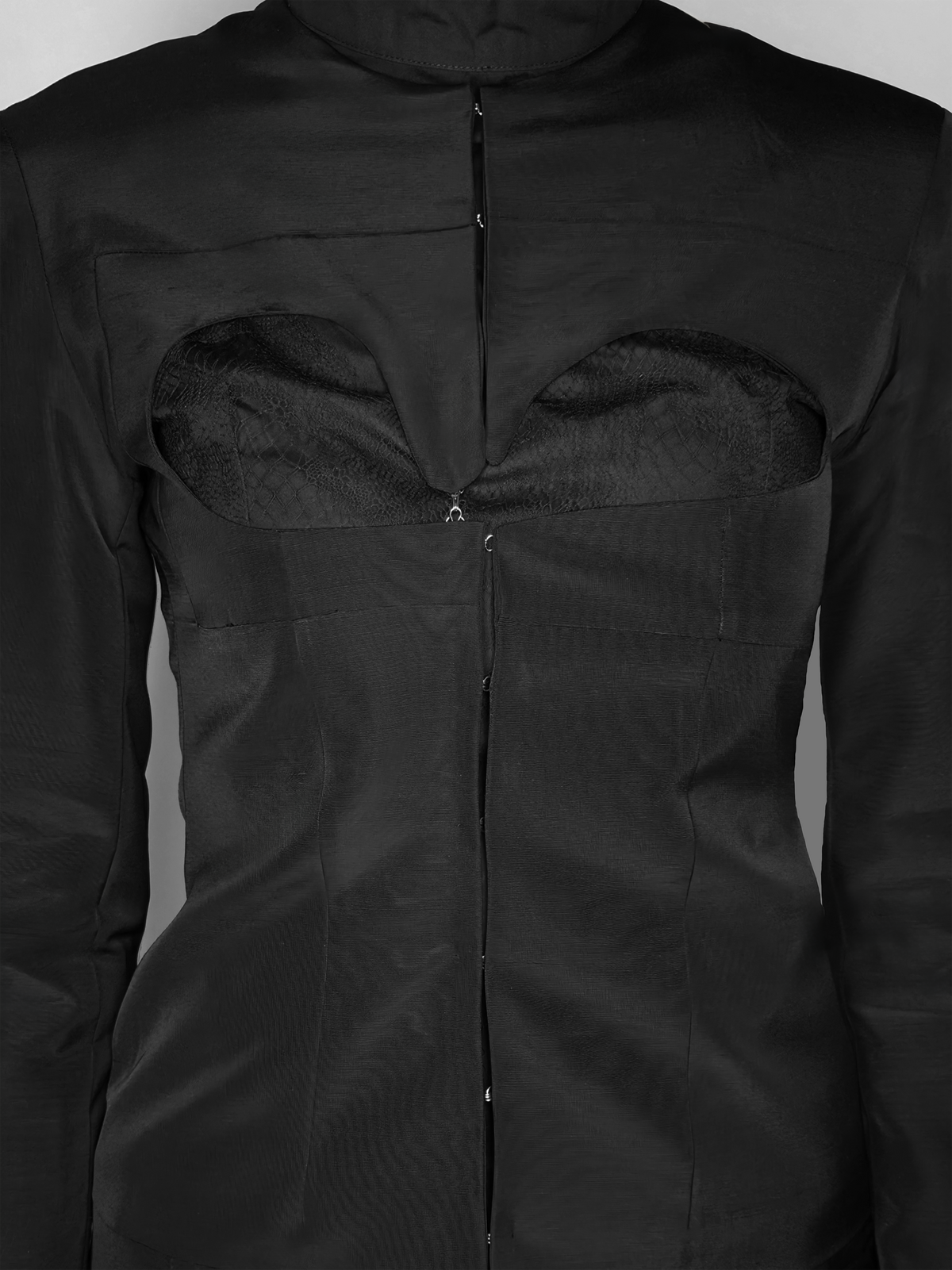 Détail de l’ouverture sur le devant de la veste noire cintrée Tyffaine faite en laine et avec le haut Théophanie.