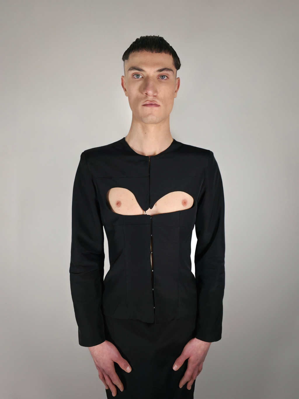 Homme portant la veste cintrée en laine et viscose, noire et avec une ouverture sur la poitrine.